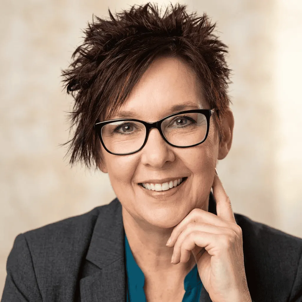 Professional woman smiling with glasses, wearing a suit. Software localization challenges.